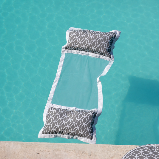 Graue chillisy Wasserhängematte mit geometrischem Muster schwebend auf kristallklarem türkisfarbenem Poolwasser – hochwertige Detailaufnahme für luxuriöse Entspannung im Pool. Hergestellt in Deutschland.
