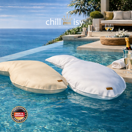 Zwei chillisy® SHAKY Poolkissen in Weiß und Creme auf einem luxuriösen Infinity-Pool mit Meerblick – schwimmende Designer-Poolkissen für exklusiven Outdoor-Komfort, genäht in Deutschland