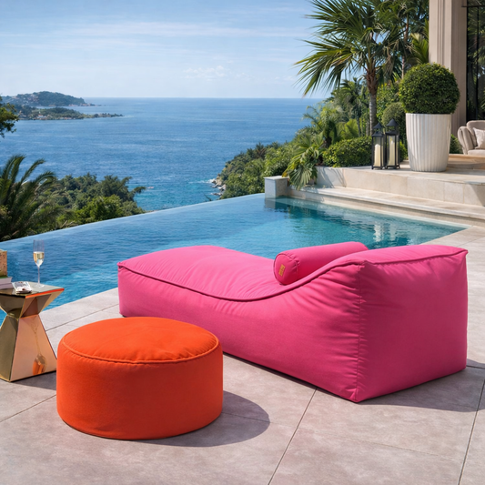 Pinkes Daybed Sonnenliege mit Nackenrolle und oragenen Pouf aus der Kollektion CHILL EASY LOUNGE von chillisy mit Meerblick am Pool