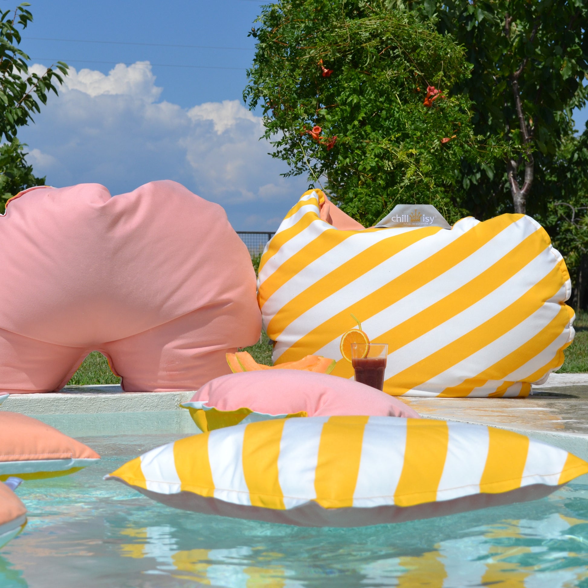 Schwimm- und Gartenkissen der Kollektion Capri von chillisy in den Farben: Gelb Weiß gestreift in Kombination mit Rosa und Aprikot.