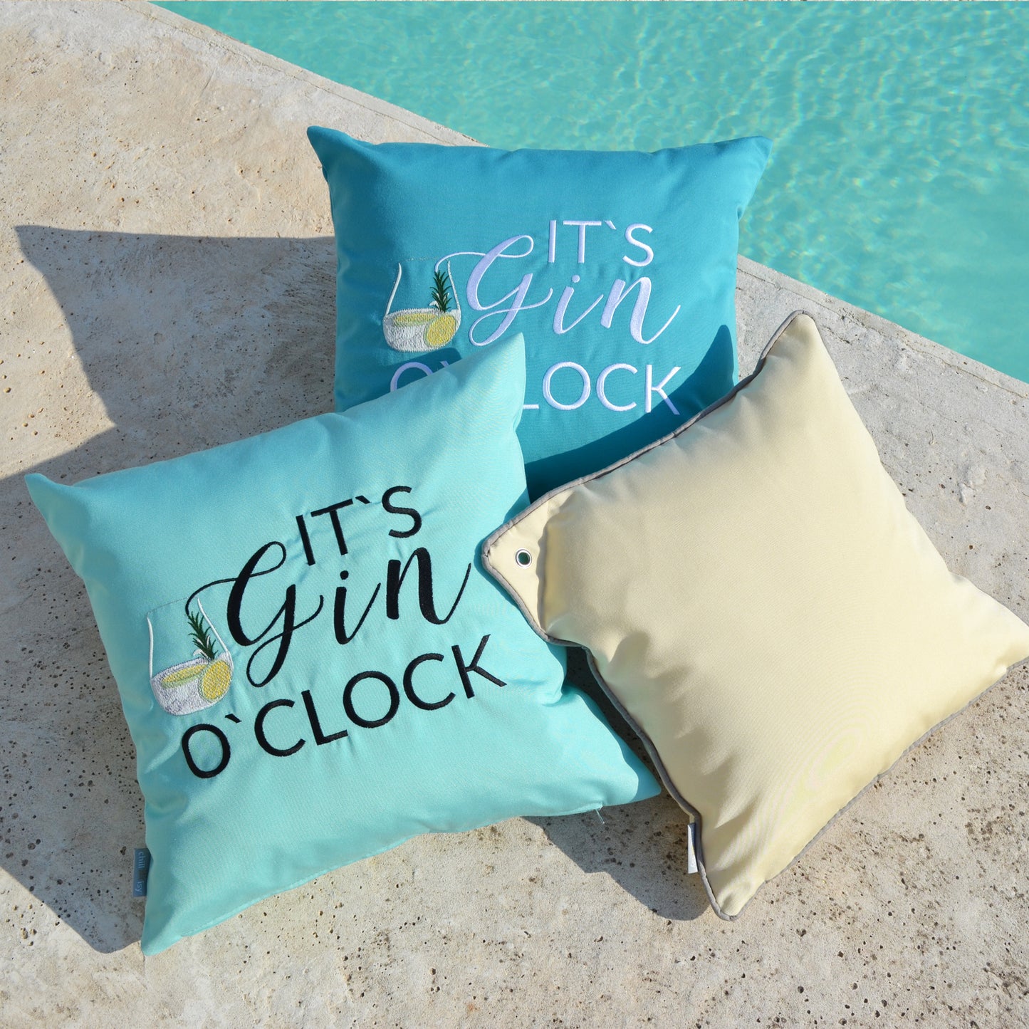 Dreier Kissen-Set u.a. Mint farbenes Kissen bestickt mit dem Motiv IT‘S GIN O‘CLOCK. Die Kissenform ist quadratisch und misst 45x45 cm.