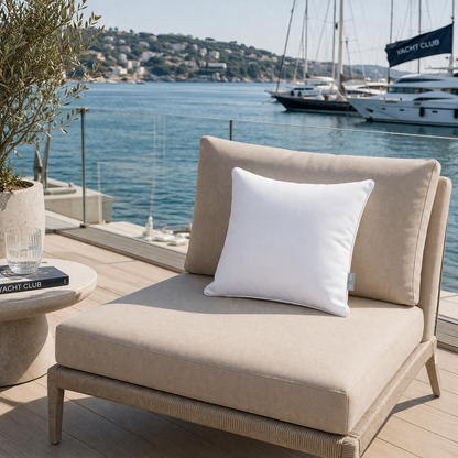 Weißes Gartenkissen witterungsbeständig  von chillisy auf beigem Gartenstuhl im Yachtclub am Meer - hergestellt in Deutschland.