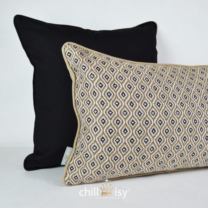 Beiges Kissen Sunbrella KOMO RAFFIA 50x30 cm mit schwarzem Kissen im Hintergrund - beide wetterfest für Outdoor und Indoor, hergestellt von chillisy in Deutschland.