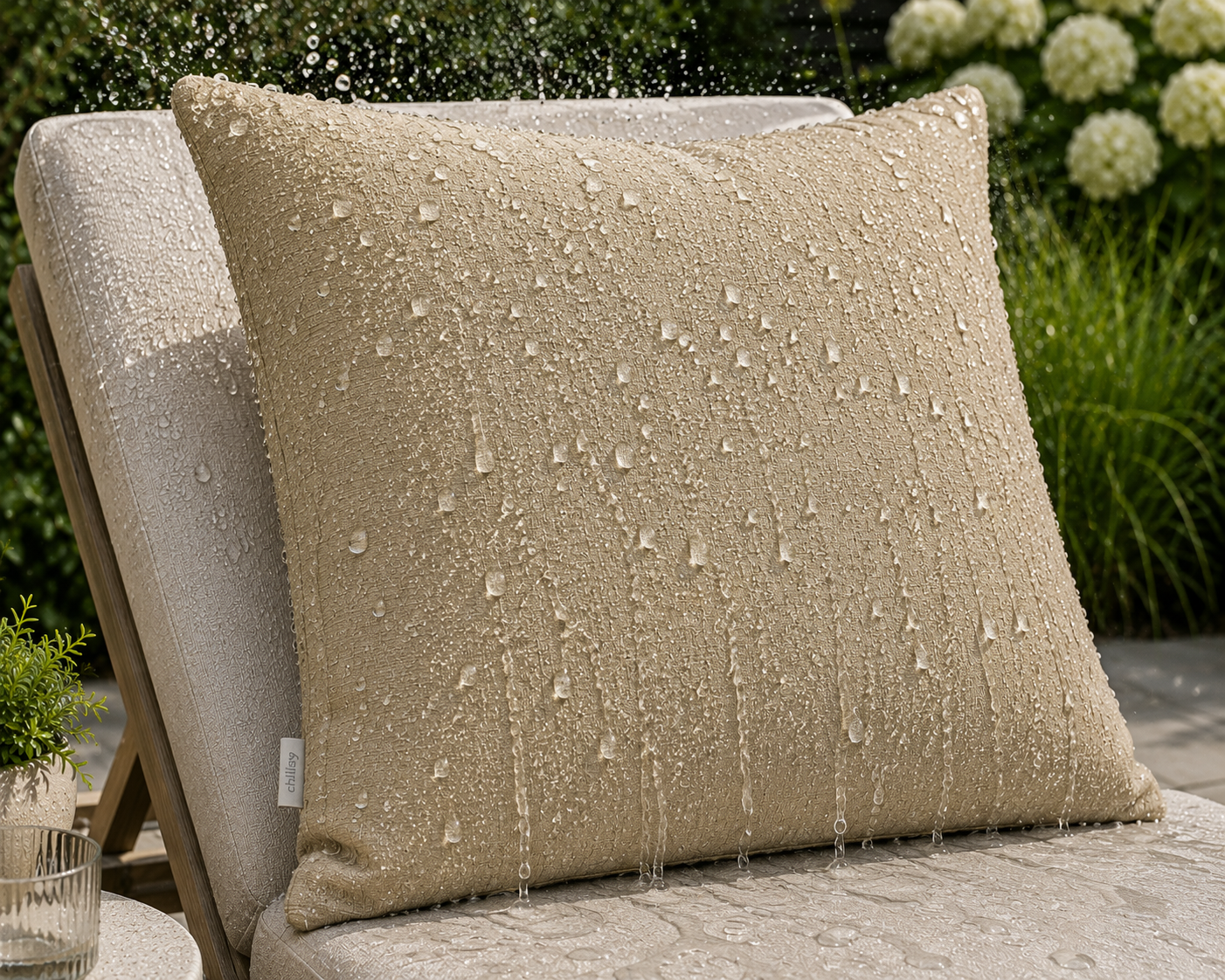 Wasserabweisende Outdoor Kissen Taupe Melange hergestellt von chillisy in Deutschland. Dargestellt auf beigem Gartenstuhl.