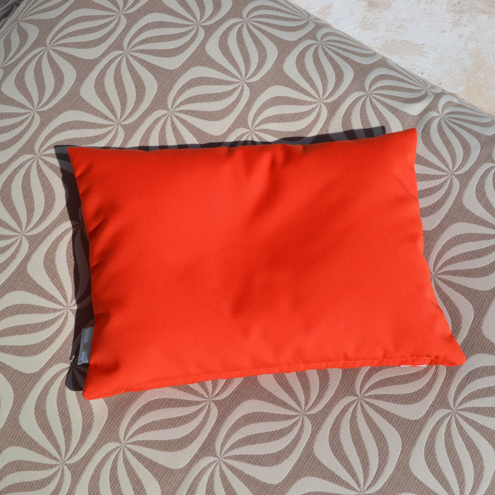 chillisy PICCOLINO Schwimmkissen und Reisekissen 30x40 cm in Hummer Orange auf einem Pool Sitzsack Butterfly von chillisy liegend am Pool – ultraleichtes Outdoor Kissen für Pool, Strand und Reise, hergestellt in Deutschland.