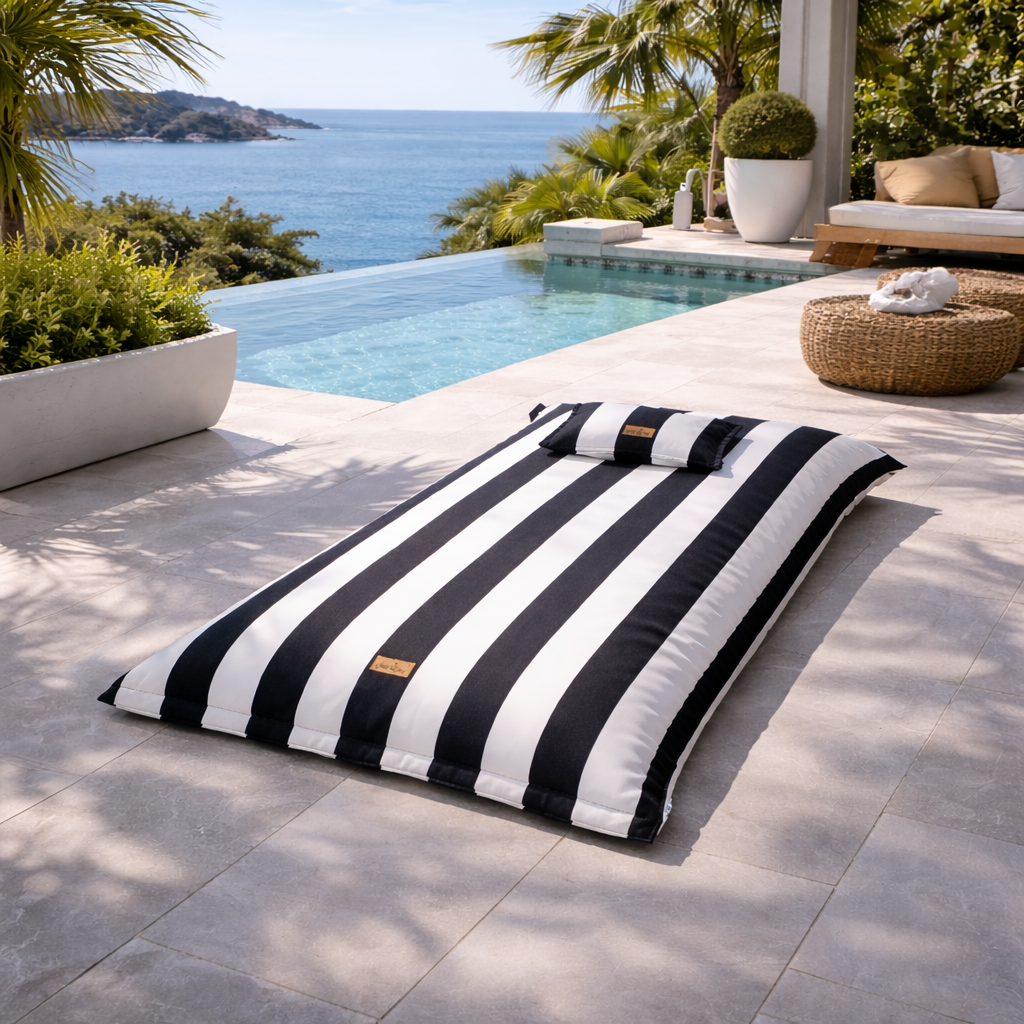 Pool Sitzsack Lungo mit 190/100 cm in schwarz/weiß von chillisy am Poolrand liegend.