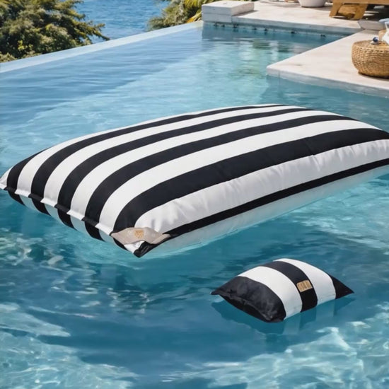 Pool Sitzsack von chillisy in schwarz weiß gestreift im Pool treibend mit Blick auf das Meer