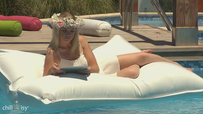Video mit weißem Poolkissen und Frau im Kleid darauf auf Pool in Mallorca schwimmend.