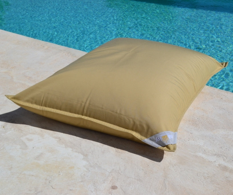 Premium Poolkissen von chillisy in der Farbe Butter Karamell Gold am Poolrand liegend.